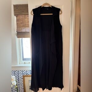 Black duster with pockets in front & pleat detail in back. You will rock this!
